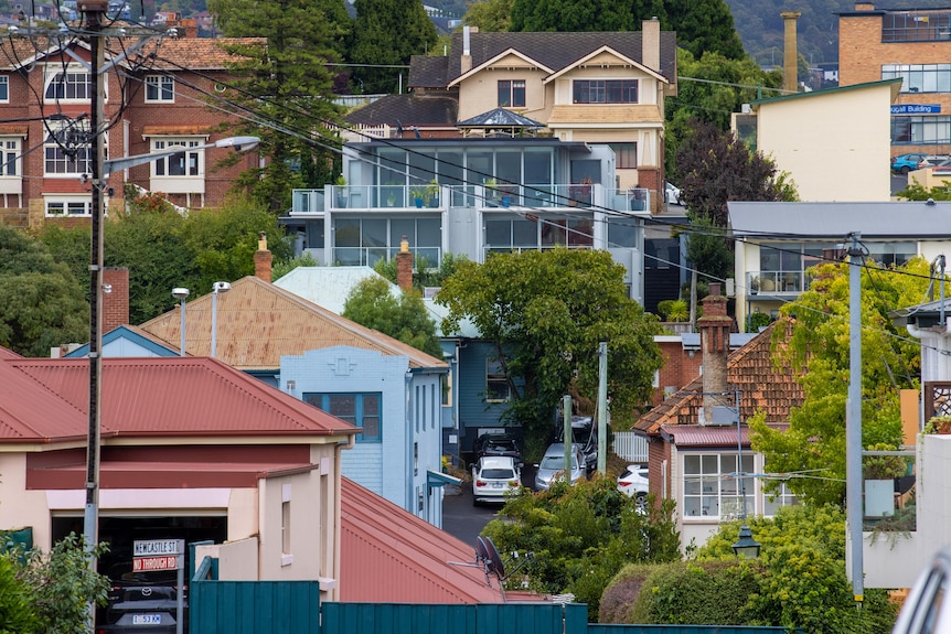 Multiple houses grouped together at different levels on a hillside.