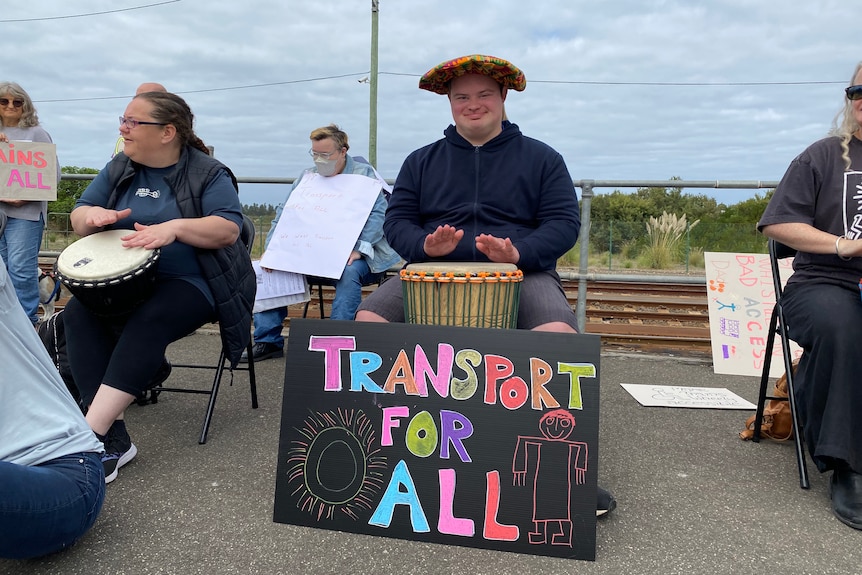 A man with a sign reading "transport for all" 