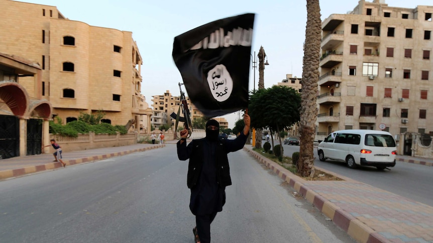 A member loyal to the Islamic State in Iraq and Syria waves an ISIS flag in Raqqa, Syria