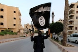 A member loyal to the Islamic State in Iraq and Syria waves an ISIS flag in Raqqa, Syria