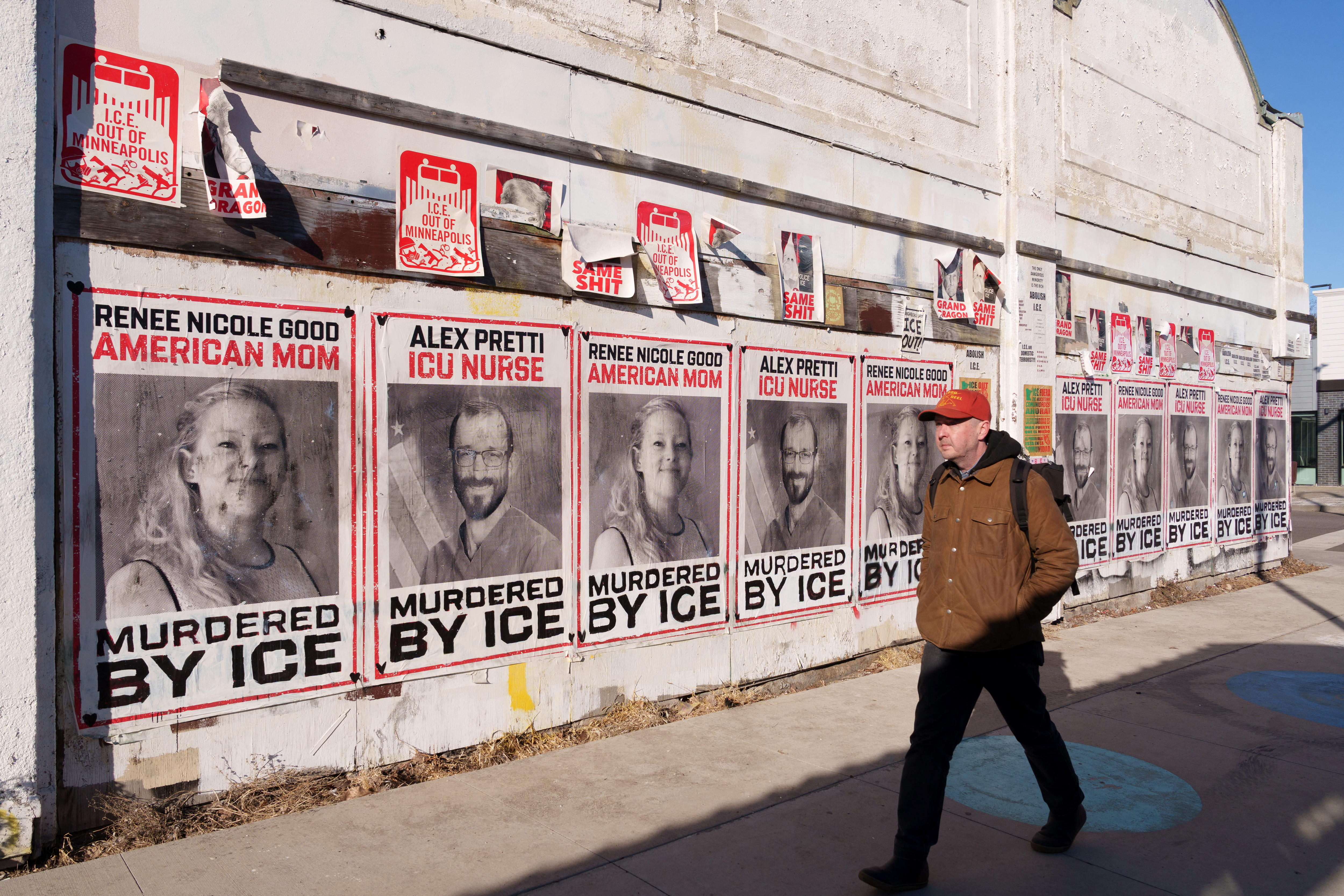 Posters showing Renee Good and Alex Pretti cover the wall of a building.