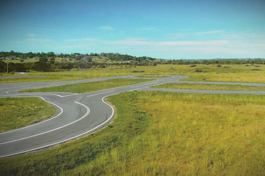 An aerial shot of a road track in a field