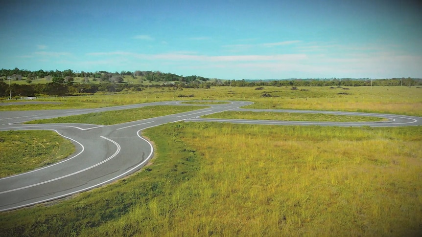 An aerial shot of a road track in a field