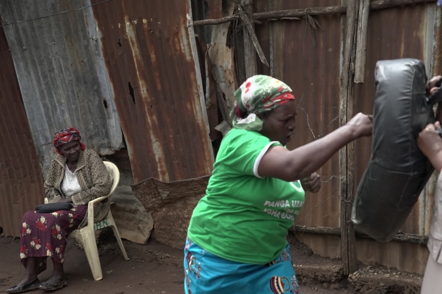 Woman striking a punching bag.