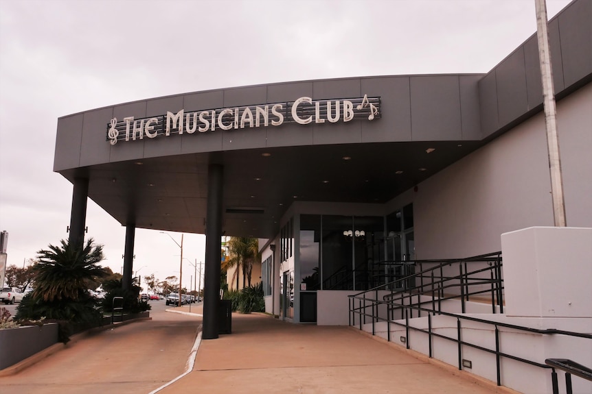 A building that says 'The Musicians Club' which includes musical notes.