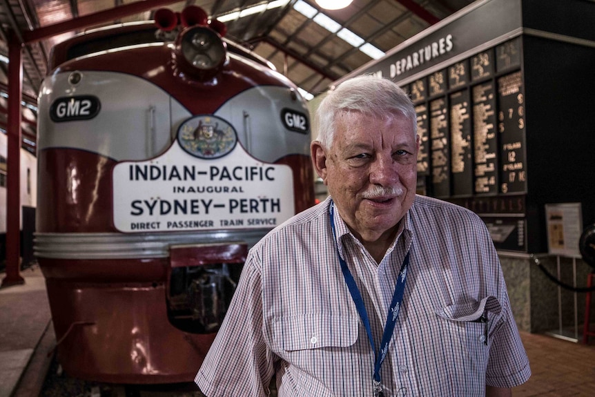 Man standing in front of old train locomotive