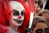 A boy dressed as a clown does his best to frighten people on Halloween in Melbourne.