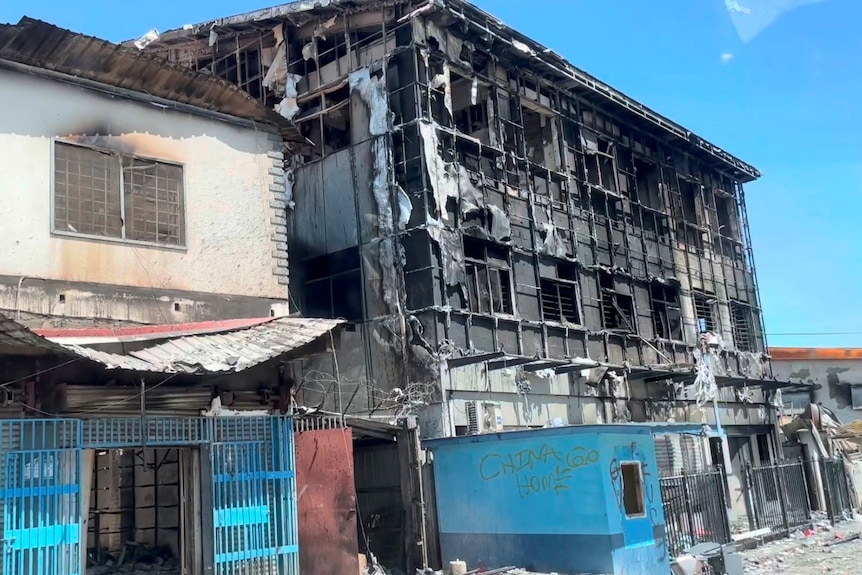 A destroyed building in Honiara with graffiti reading 'China go home'