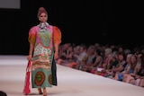 a female model wearing a colourful dress and head piece