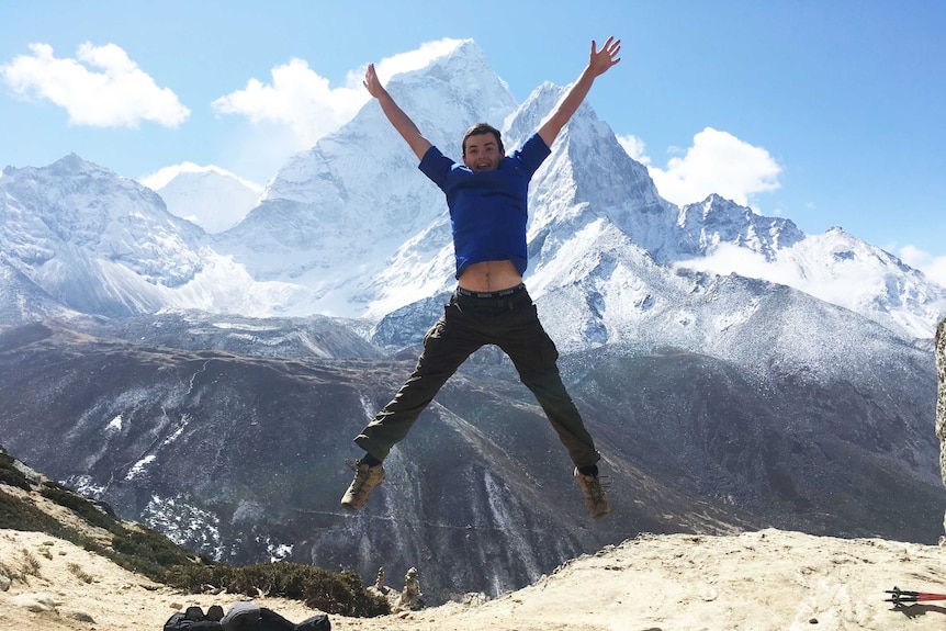 Zack Stayner does a star jump in front of the west face of Ama Dablam.