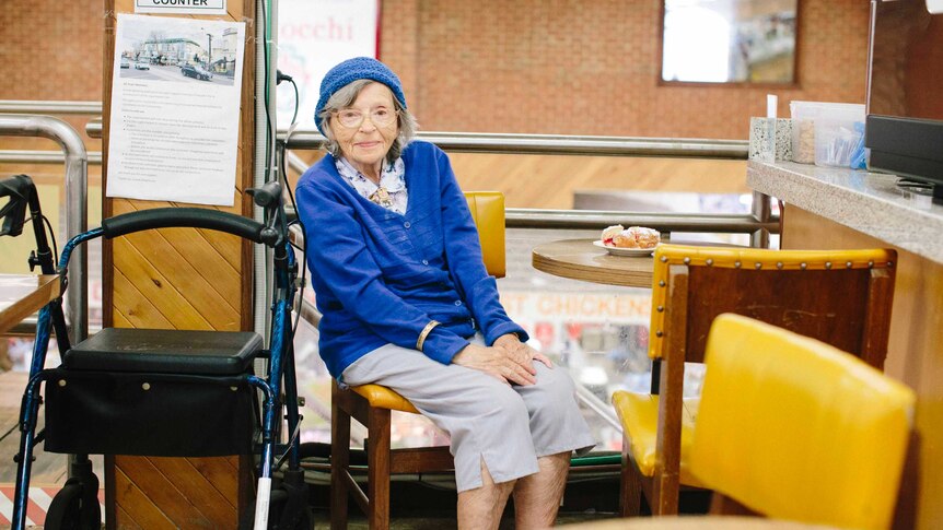 Moyia, 86, sits in the cafe with a doughnut