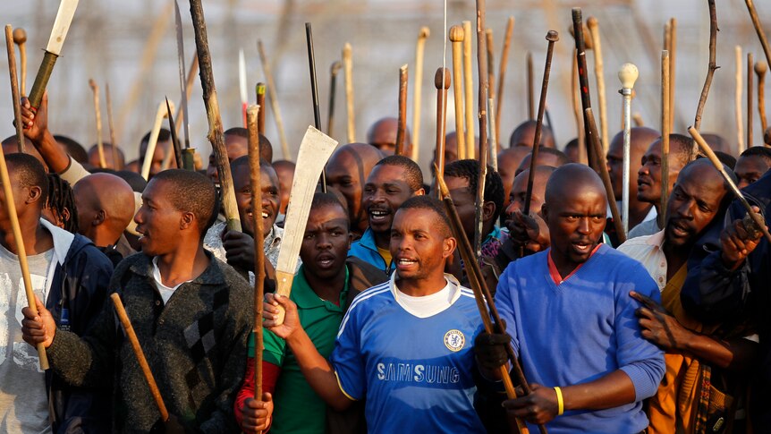 Striking miners chant slogans outside a South African mine in Rustenburg, South Africa.