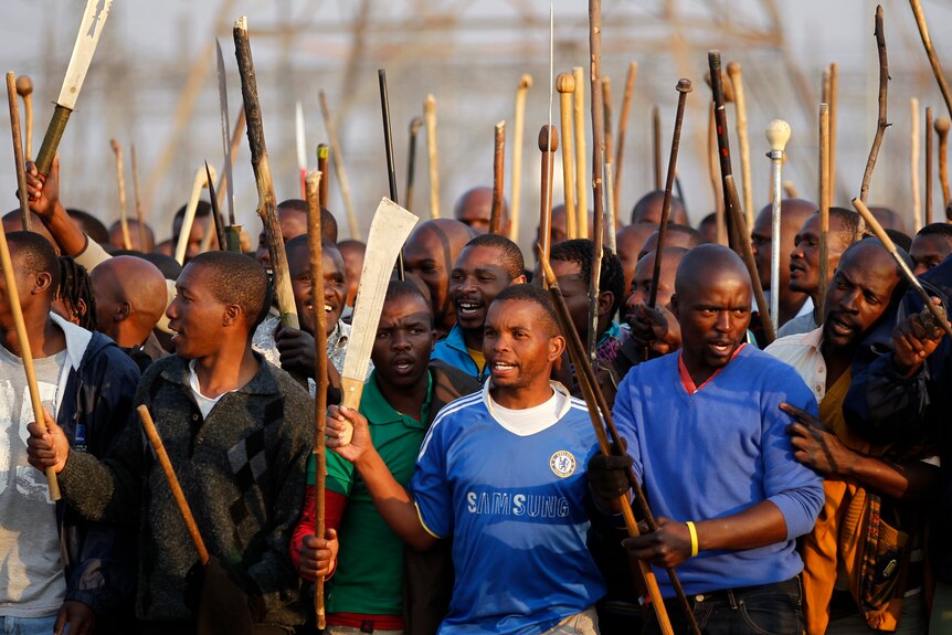 Striking miners chant slogans outside a South African mine in Rustenburg, South Africa.