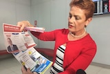Pauline Hanson holds up Labor and Liberal how to vote flyers