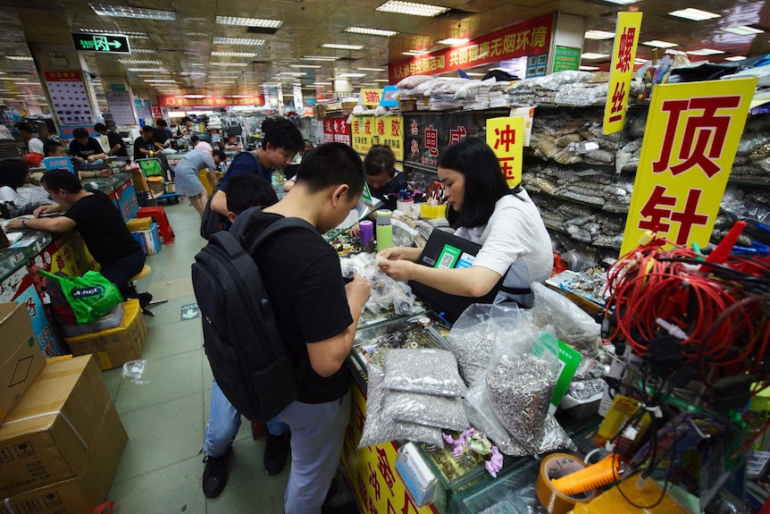 Crowds walking through an aisle in a marketplace