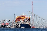 A container ship beneath a collapsed battle bridge