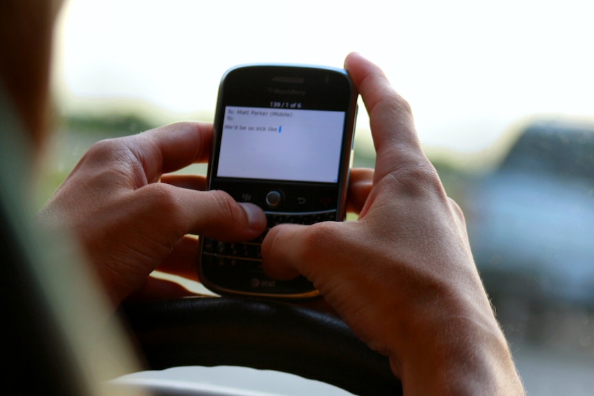 Close of a man's hands as he texts in the car