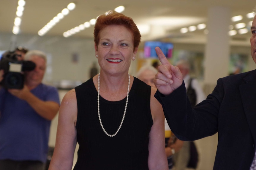 One Nation leader Pauline Hanson walks towards a camera.