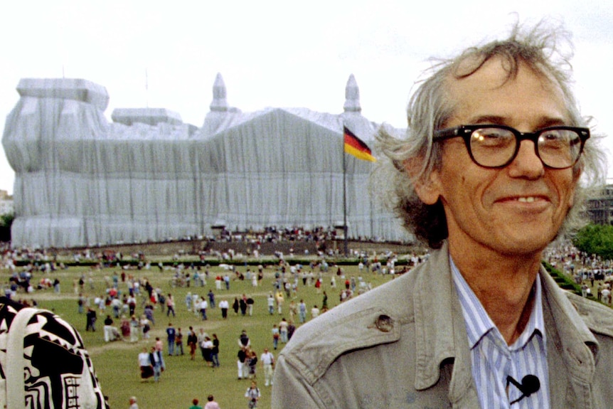 Conceptual artist Christo poses for photographers in front of the wrapped Reichstag