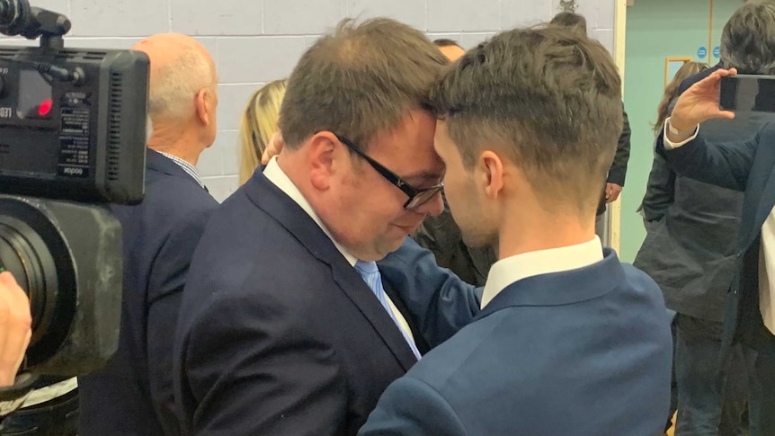 Conservative candidate Mark Fletcher embraces his husband Will.