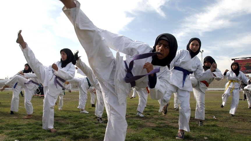 Female Afghan athletes perform martial arts during a demonstration for women's day in Kabul, 2004. 
