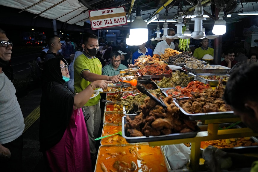 Customers are served food from a stall on a roadside