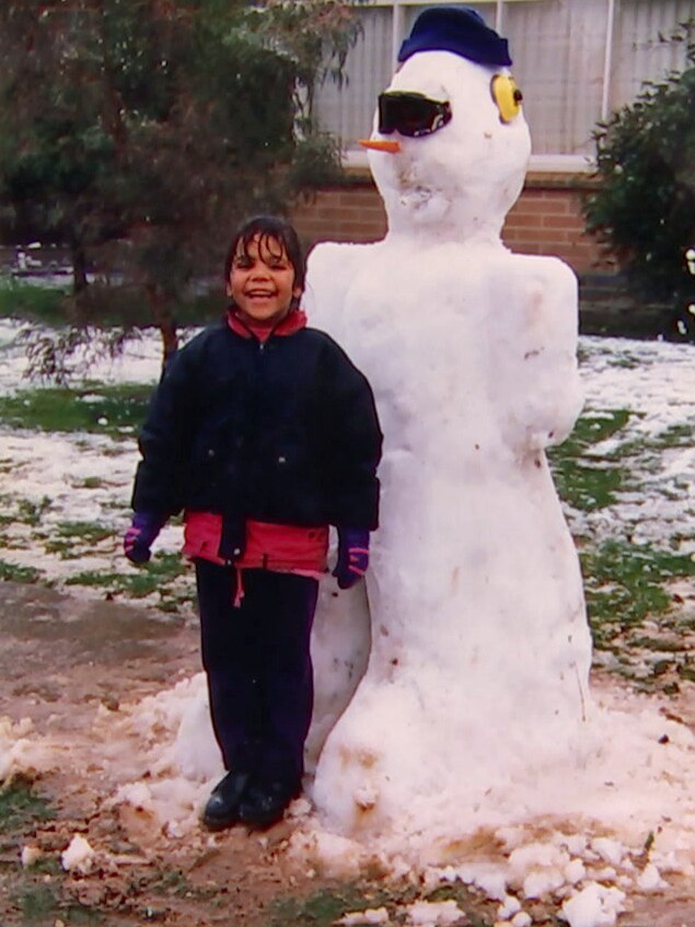A young Luana with a snowman.