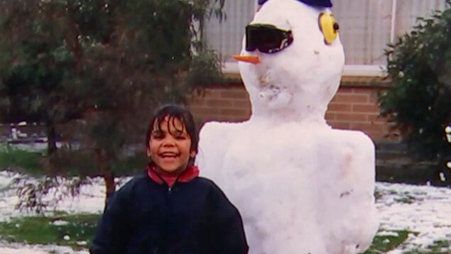 A young Luana with a snowman.