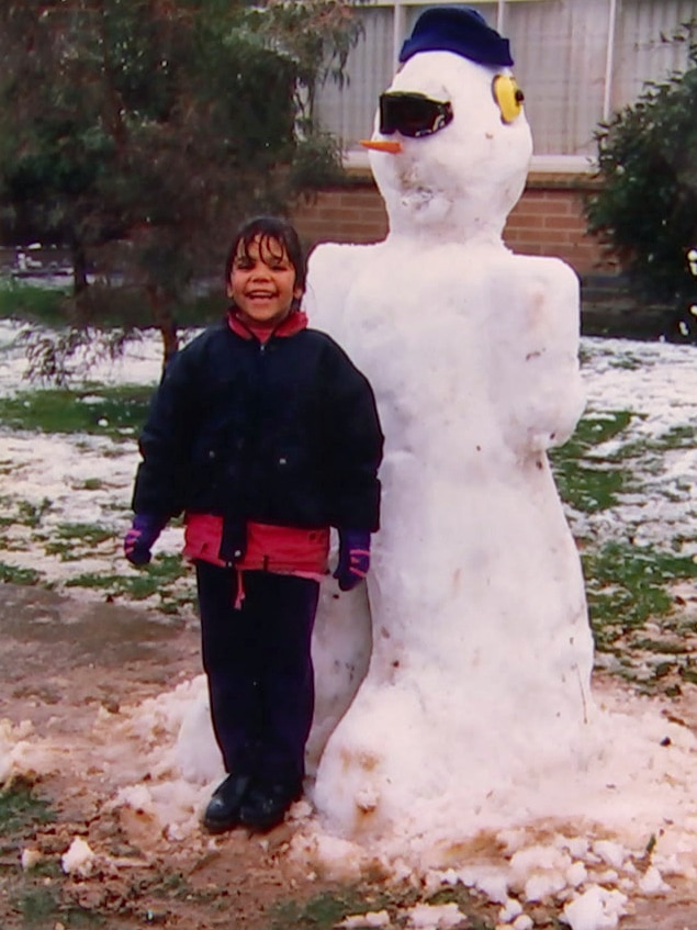 A young Luana with a snowman.