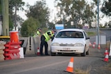 A white Commodore pulled over in a police checkpoint.