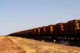 Lots of open air carriages filled with red rocks.