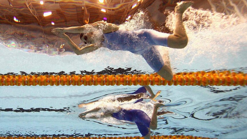 Three competitors race in the women's 50-metres breaststroke
