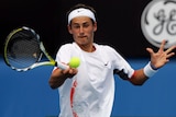 Bernard Tomic returns a shot