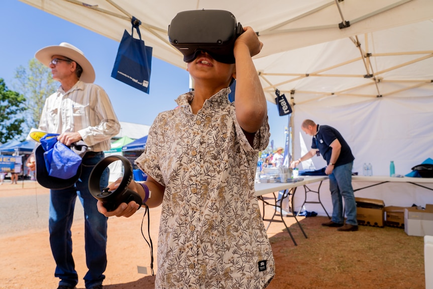 A young boy wears a virtual reality headset.