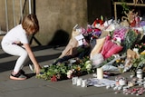 A girl leaves flowers for the victims of an attack on concert-goers at Manchester Arena, in central Manchester.