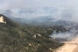 A plane dumps water on part of a bushfire on Fraser Island.
