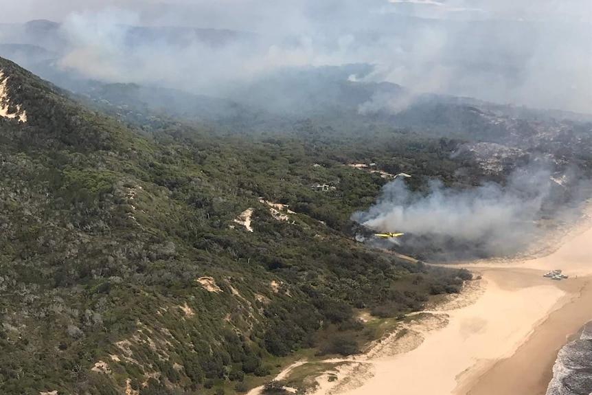 A plane dumps water on part of a bushfire on Fraser Island.