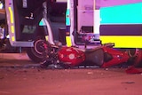 A damaged red motorcycle laying on the road in Adelaide's north