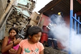 A health worker fumigates a house as residents wait outside during a campaign against the Zika virus.