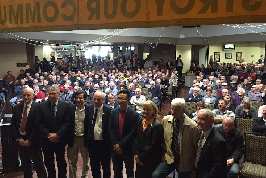 Politicians standing in front of crowd