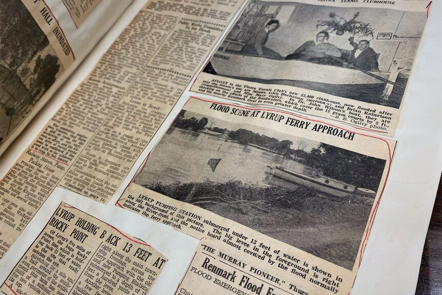 Brown and old newspaper clippings highlighted in red pen. The article title says FLOOD SCENE AT LYRUP FERRY APPROACH