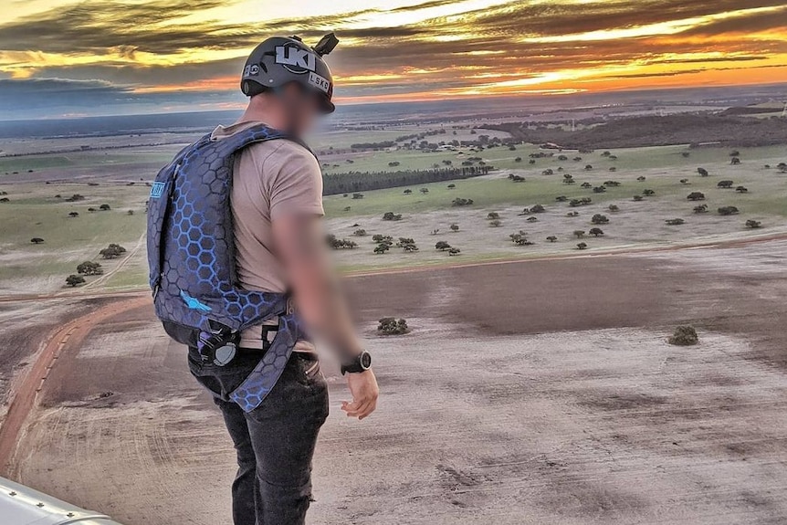 A photo of a man about to skydive.