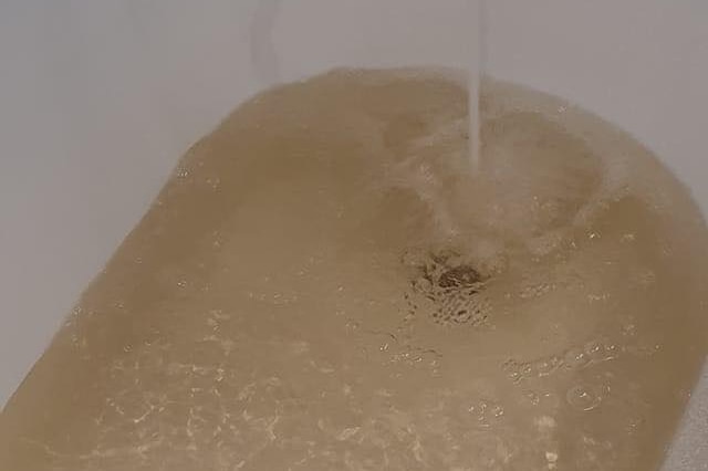 Water coming out of a bath tub tap a light brown colour.