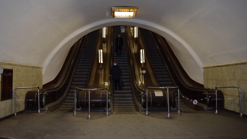 Escalators inside a metro station lead up towards ground level
