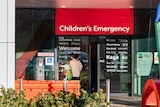 A red sign with the words "Children's Emergency" above a door.