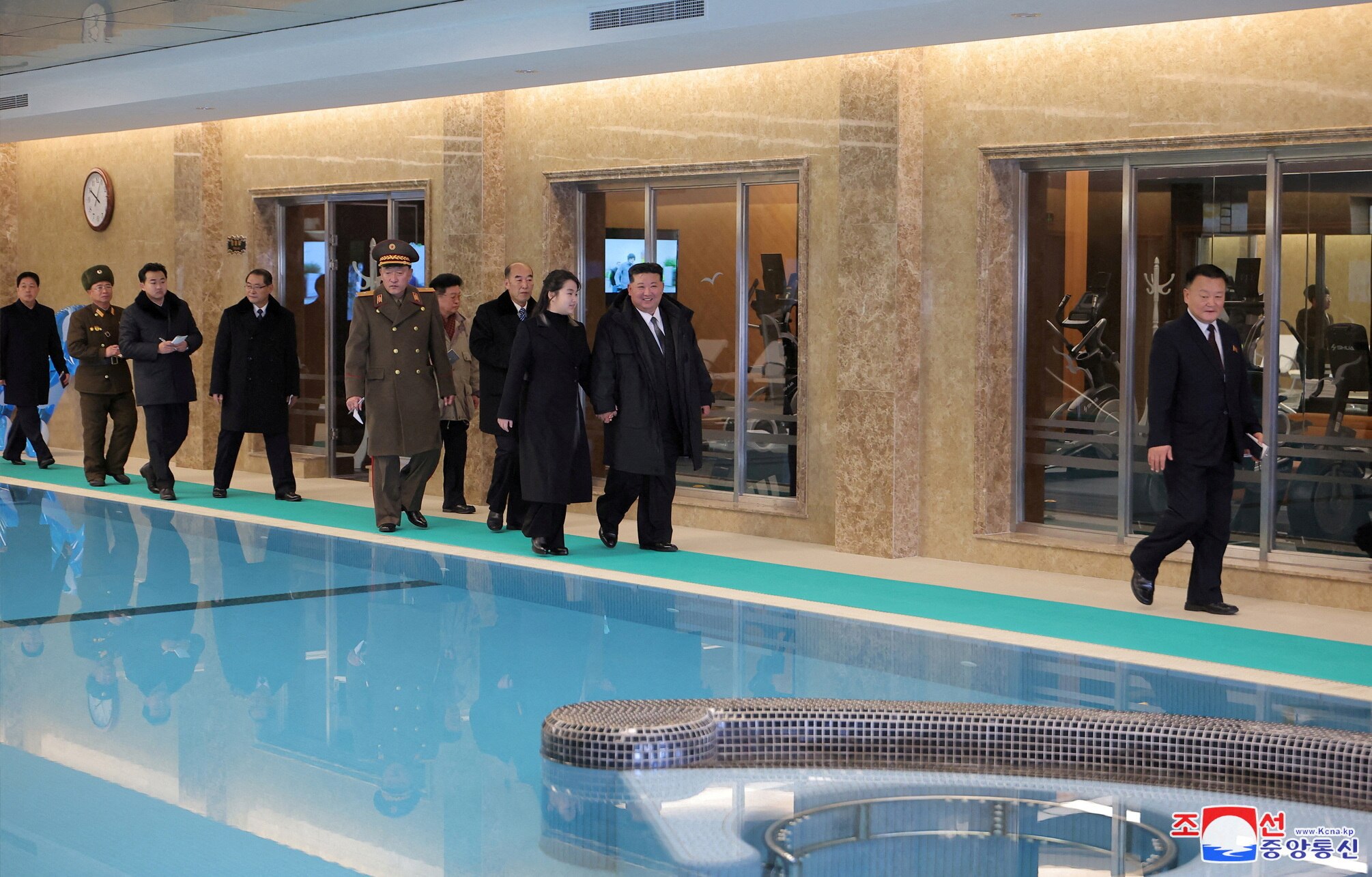   Kim Jong Un y su hija Kim Ju Ae caminan junto a una piscina cubierta.