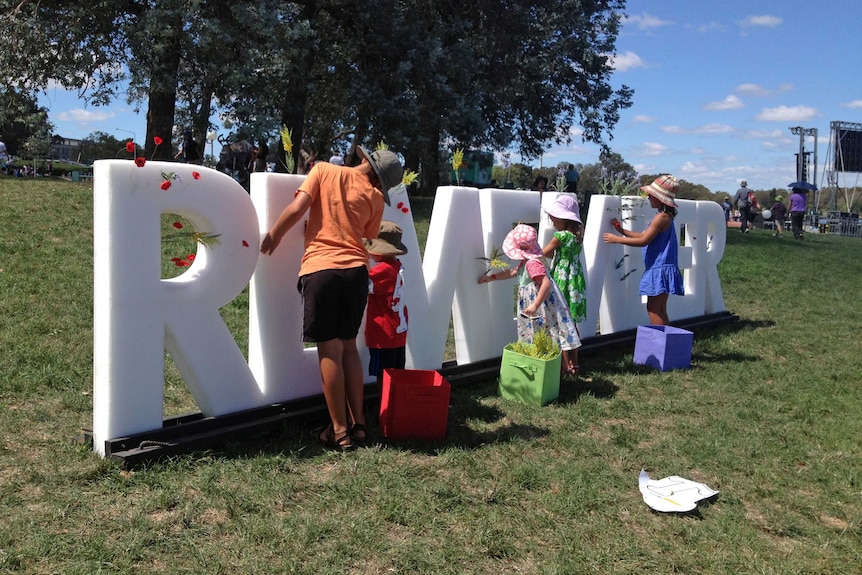Children decorate the giant word 'remember' at Regatta Point.