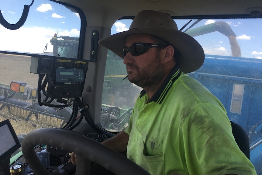 Dean Ferguson in his harvester stripping wheat at Curban, south of Coonabarabran.