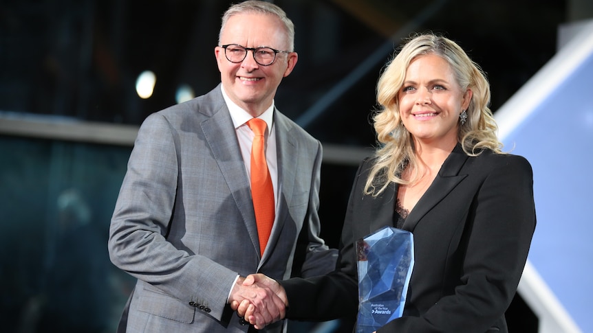 Prime Minister Anthony Albanese shakes hands with the new Australian of the Year for 2023, Taryn Brumfitt