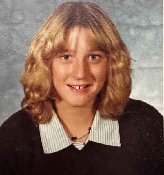 A teenage girl posing for what looks like an old school photo. 